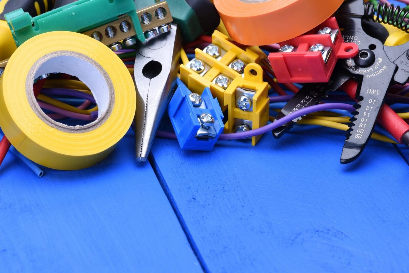 A blue table with electrical supplies and tools.