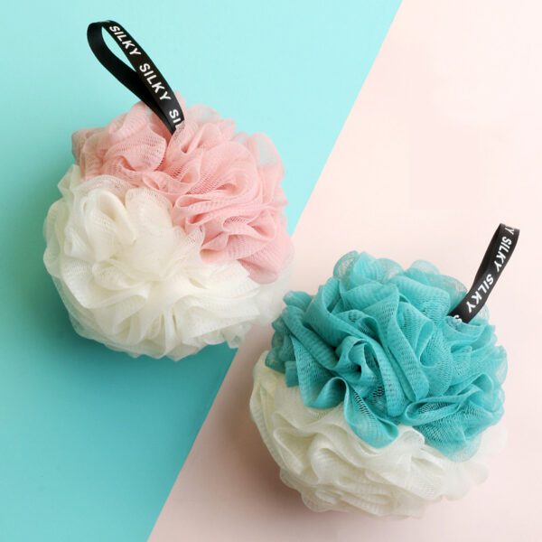 Two Shower Bath Sponges Loofahs Balls on a blue and pink background.