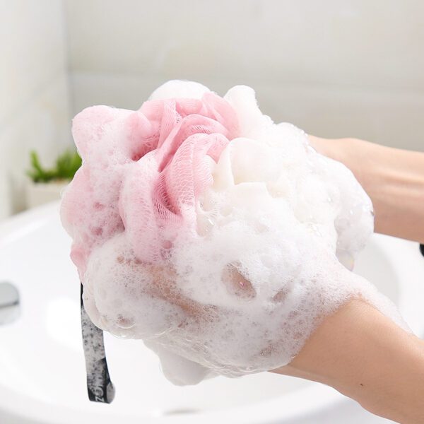 A woman is washing her hands with Shower Bath Sponges Loofahs Balls in a sink.