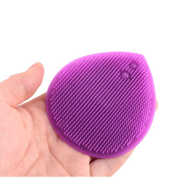 A person holding a Silicone Cleaning Face Scrubber Brush in their hand.